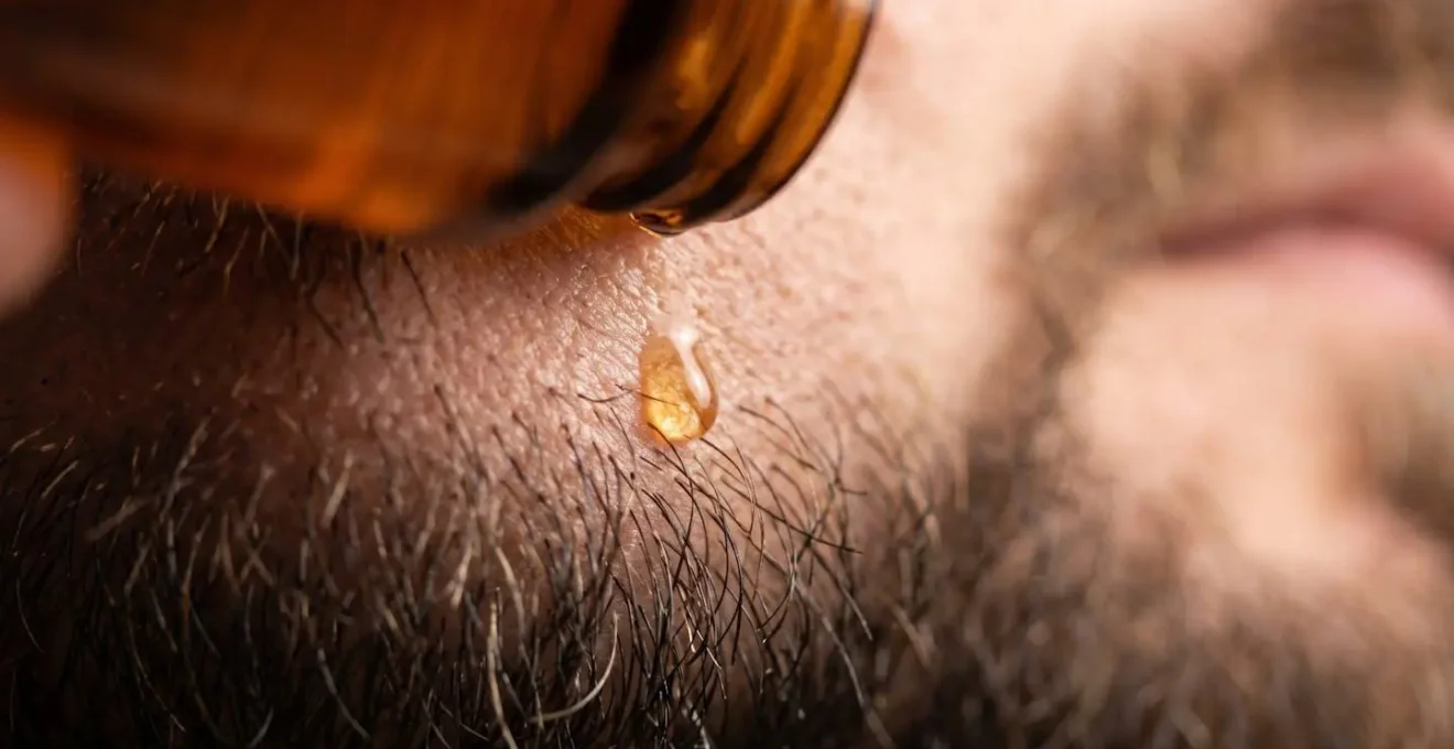 Close-up of cologne being applied to pulse points below the beard line